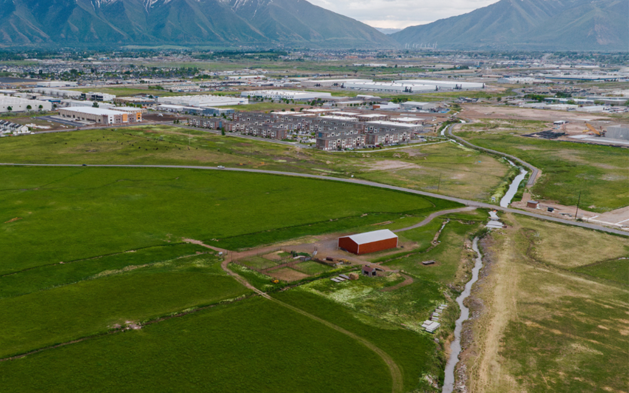 An aerial view of farm land. A mountain looms in the distance.