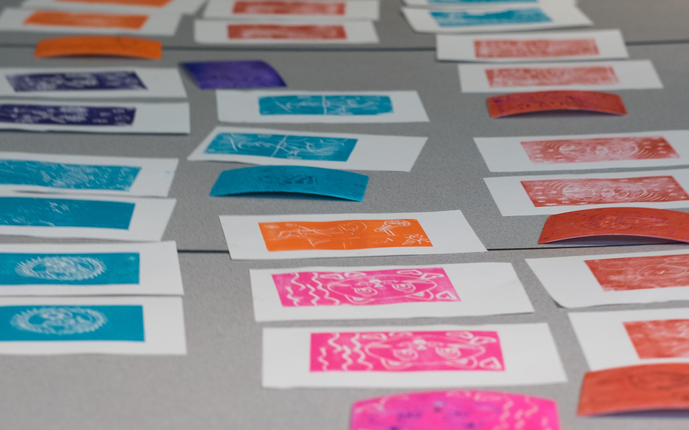 Third Saturday Printmaking Colorful prints laid out on a table.
