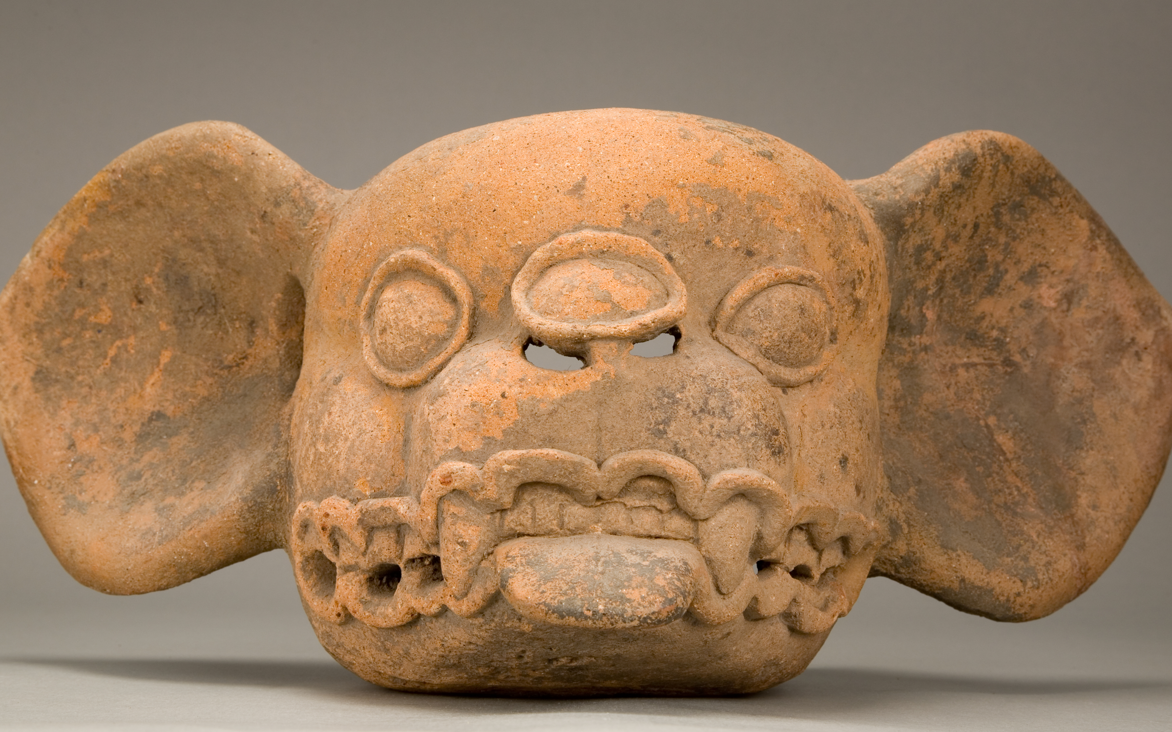 Bat Head Effigy A red ceramic bat head effigy.