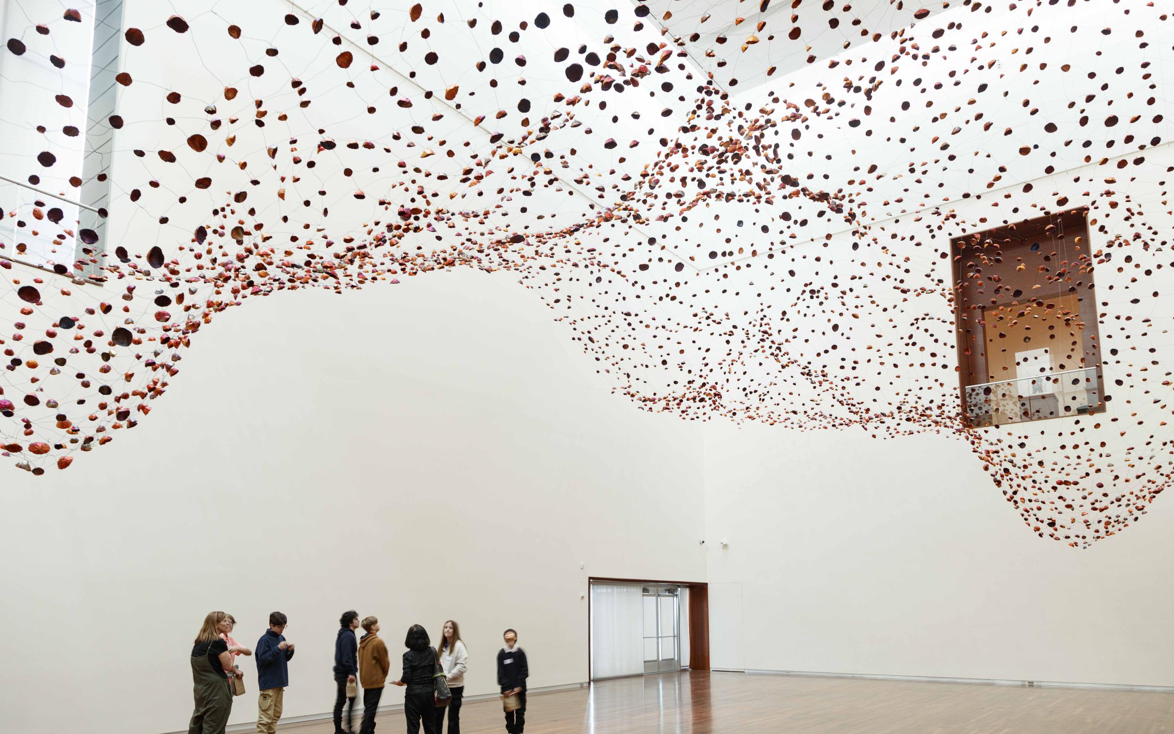 A group of people standing under the installation "Stone on Boundary"