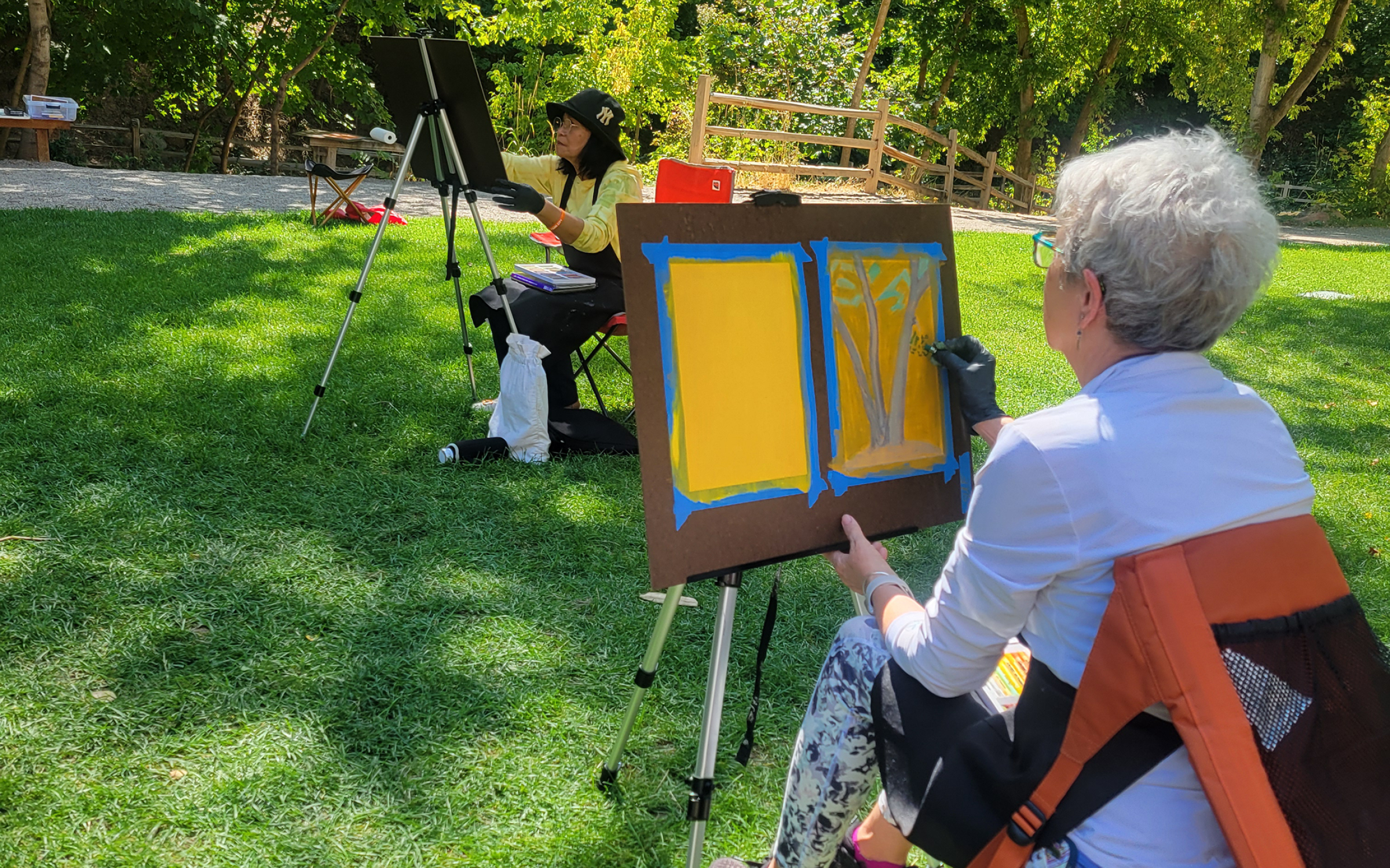 Plein Air Painting Two people paint in a park.