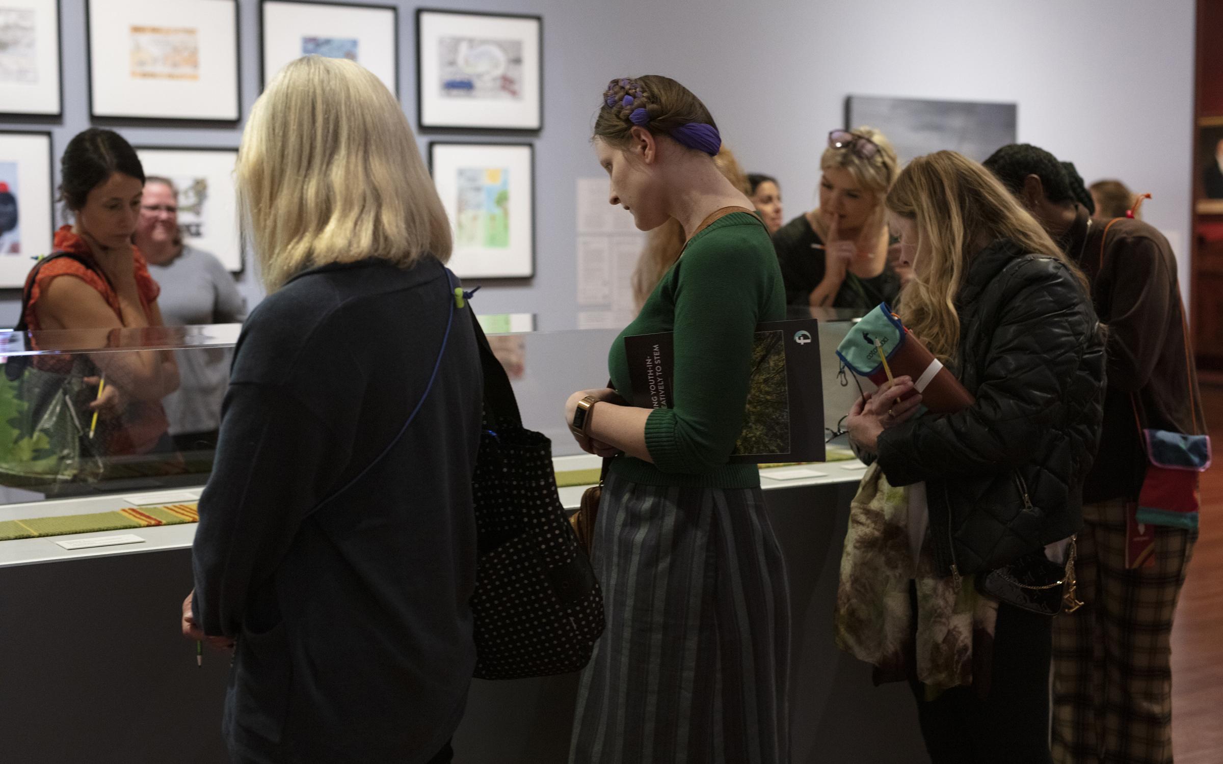 Educators look carefully at art work.