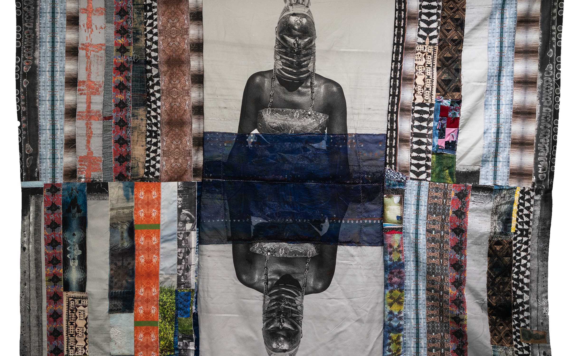 salt 17: Adama Delphine Fawundu A patchwork cloth tapestry with a print of a person in the middle.