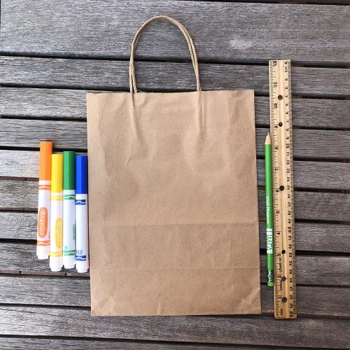 paper bag with markets, a pencil and a ruler lined up together