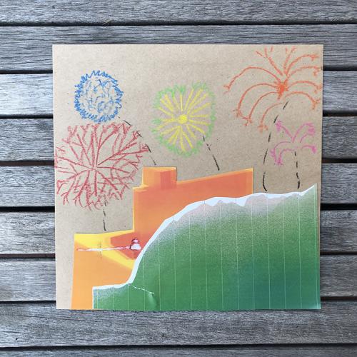 a square piece of cardboard with a collage of a green hill, orange building and fireworks