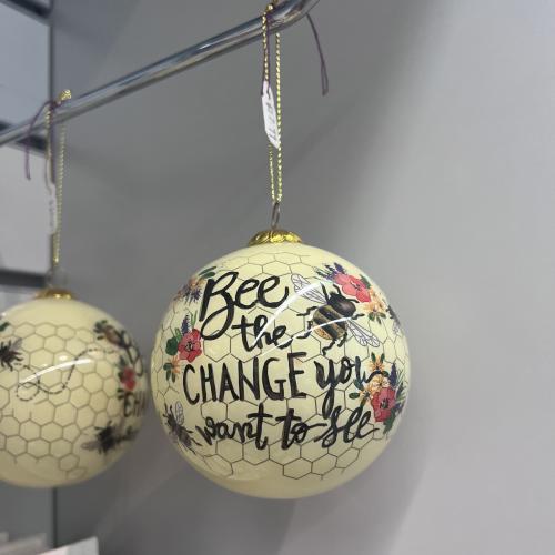 A yellow ornament that says, "Bee the change you want to see"