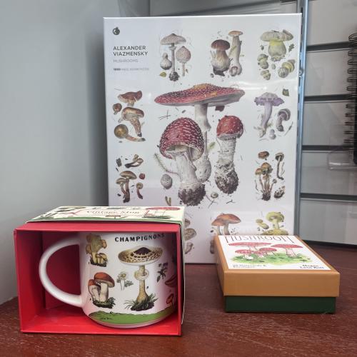 A mug, puzzle and box of cards with pictures of different types of mushrooms on each.