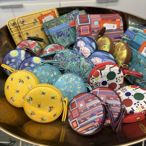 a bowl of an array of small, bright colored coin bags with zippers and wallets.