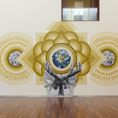 A geometric mural with gold script and two hands holding the globe.