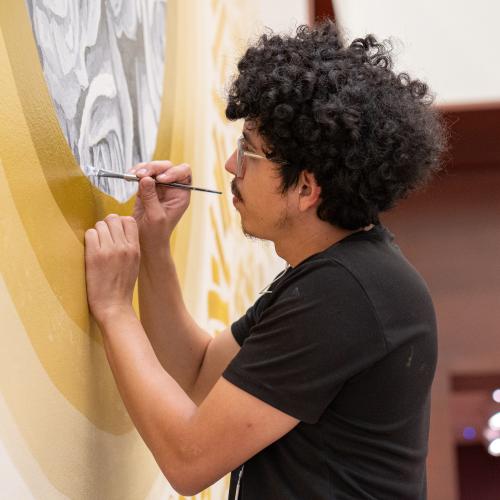 An artist paints a mural.