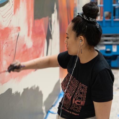 An artist paints a colorful mural.