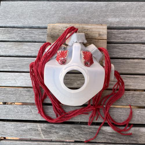 All contents glued to the cut gallon jug to form a mask shape