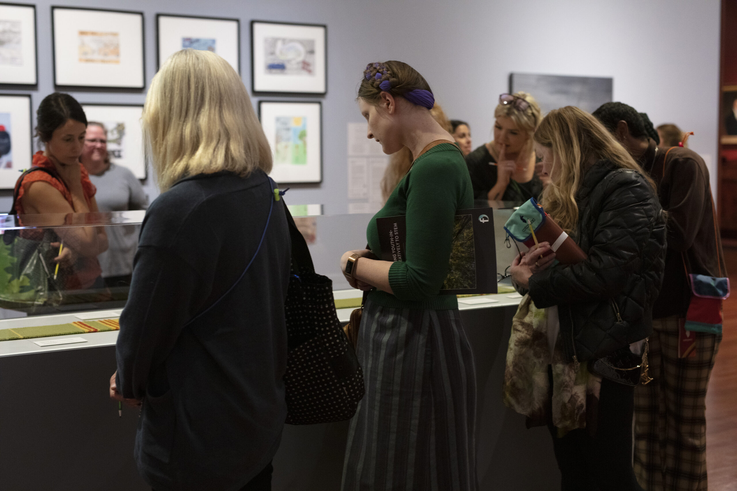 A group of educators look carefully at art.