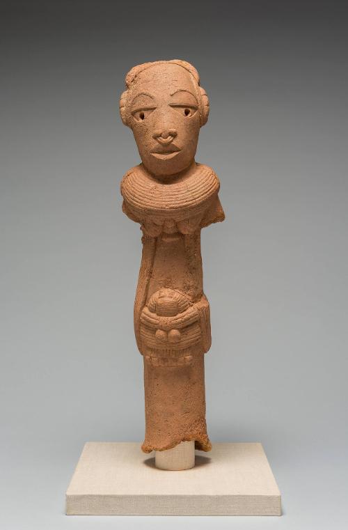 A red terracotta figure of a person holding a basket.