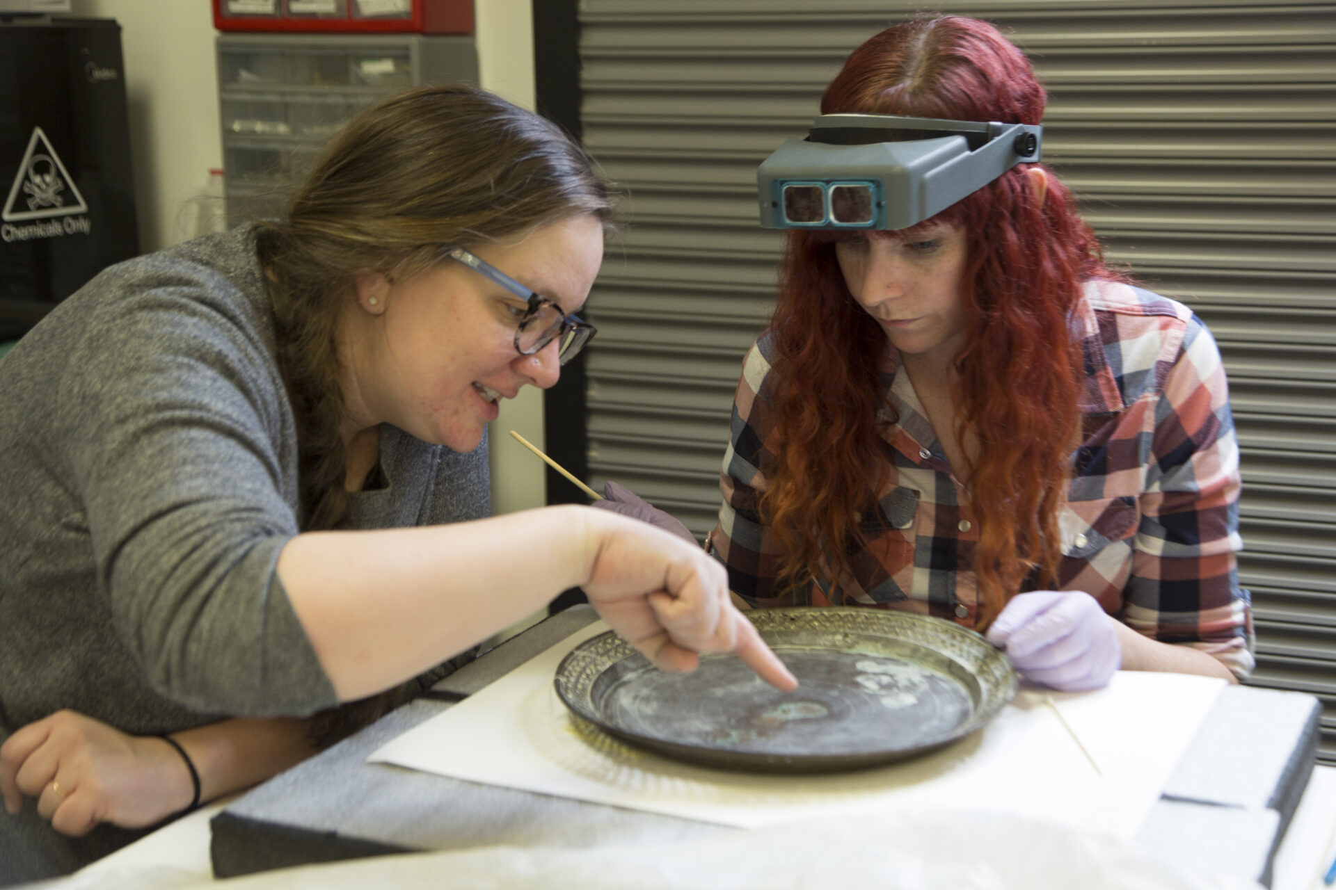 Conservator Robyn Haynie works with IMLS intern Rebekah Abbot to assess a 500-year-old Chinese gong.