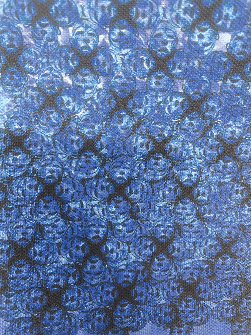 Close-up of many small, shiny blue bubbles clustered together on a surface, reflecting light and creating a textured, patterned appearance.